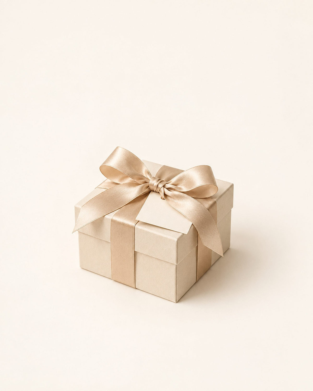 Boîte cadeau nouée d'un ruban de soie champagne